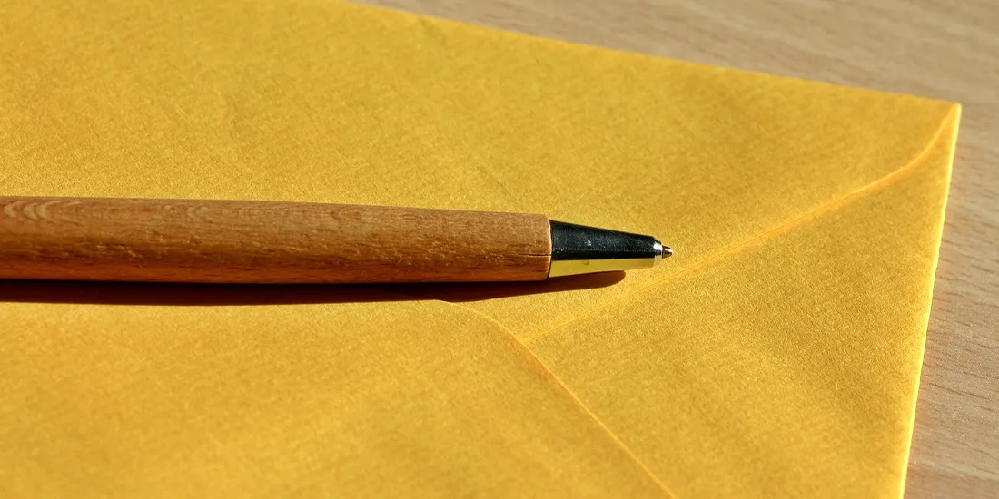 Gelber Briefumschlag mit Stift